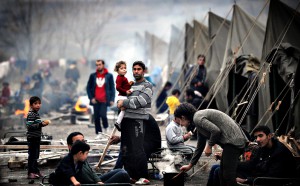 A Syrian refugee holds a baby in a refug...A Syrian refugee hold